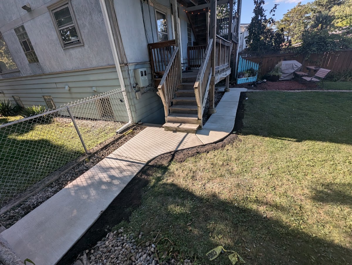 Wide view of a concrete walkway beside a residential porch